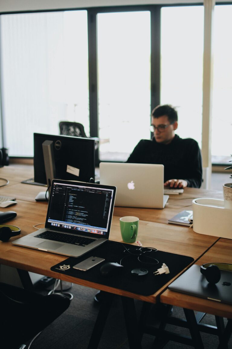 Design team collaborating in a modern workspace with laptops