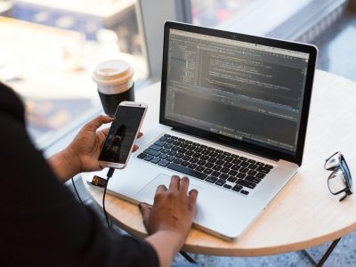Innovative Mobile App Development Developer creating a mobile app interface with code and smartphone screen preview
